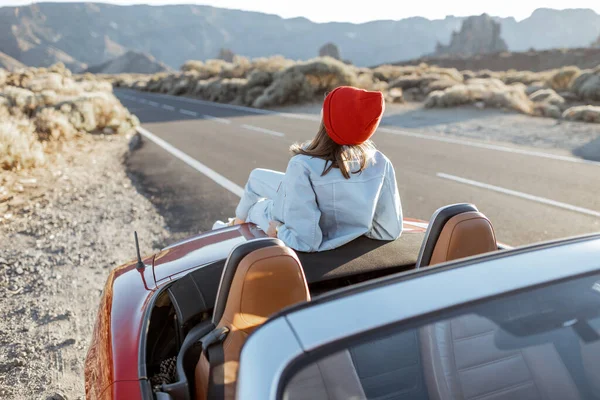 Woman traveling by car on a desert valley — Stockfoto