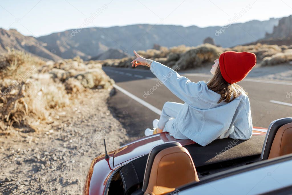 Woman traveling by car on a desert valley