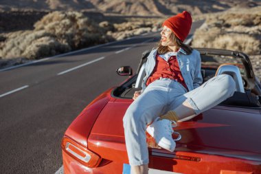 Woman traveling by car on a desert valley