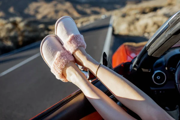 Femme tirant les jambes par la fenêtre de la voiture sur le bord de la route — Photo