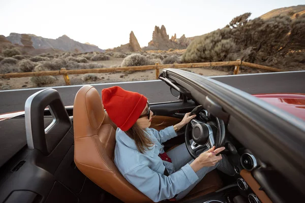 Woman traveling by cabriolet on the desert road — Zdjęcie stockowe