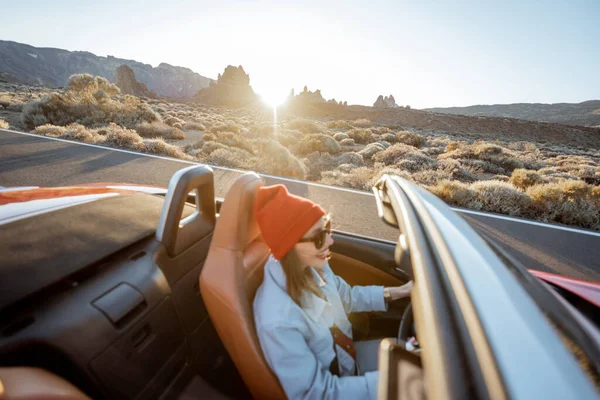 Жінка подорожує на кабріолеті на пустельній дорозі — стокове фото