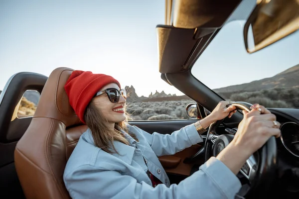 Woman traveling by cabriolet on the desert road — Stock fotografie