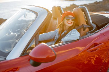 Kayalık kıyı şeridinde arabayla seyahat eden bir kadın