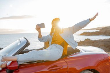 Woman vlogging on phone while travel on the ocean coast