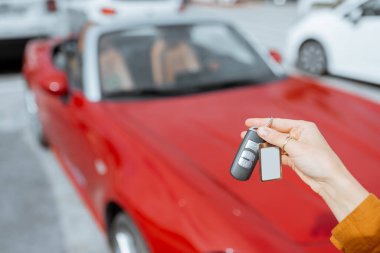 Woman holding keychain at the car parking