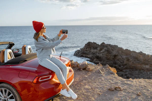 Frau mit Auto an der felsigen Küste unterwegs — Stockfoto