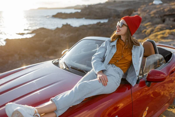 Woman traveling by car on the rocky coastline — Stock Photo, Image