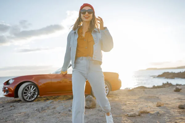 Woman traveling by car on the rocky coastline — Stock Photo, Image