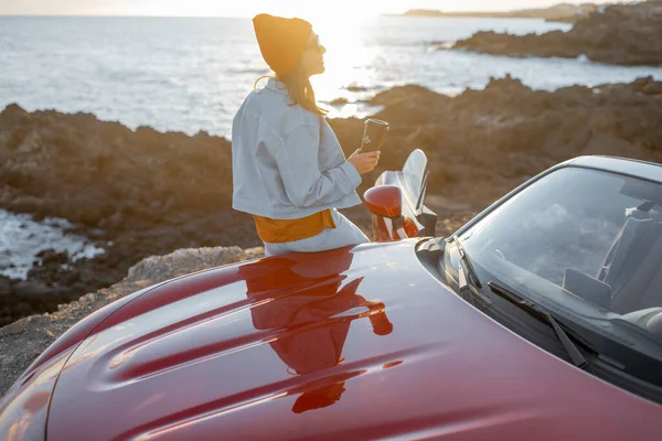 Woman traveling by car on the rocky coastline — Stock Photo, Image