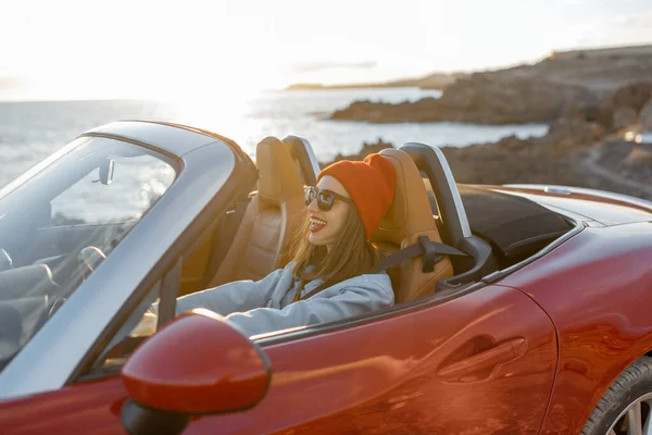 Woman traveling by car on the rocky coastline — Stock Photo, Image