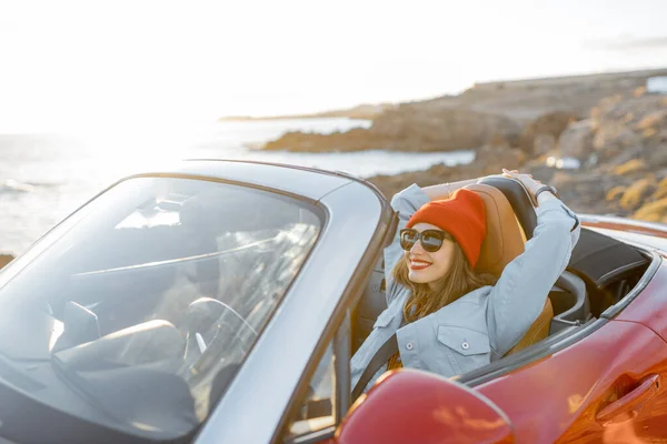 Woman traveling by car on the rocky coastline — Stock Photo, Image