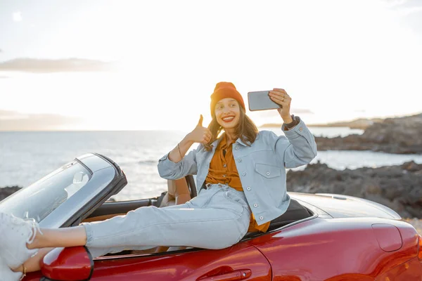 Женщина делает видеоблог по телефону во время путешествия по океанскому побережью — стоковое фото
