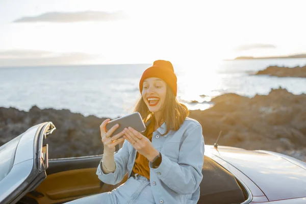 Woman vlogging on phone while travel on the ocean coast — Stockfoto