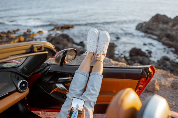 Frau mit Auto an der felsigen Küste unterwegs — Stockfoto