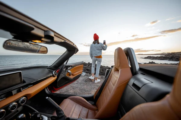 Woman traveling by car on the rocky ocean coast — 图库照片