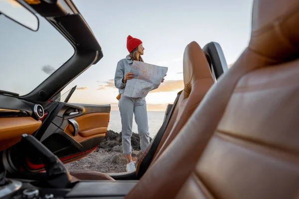 Woman traveling by car on the rocky ocean coast — Stock Fotó