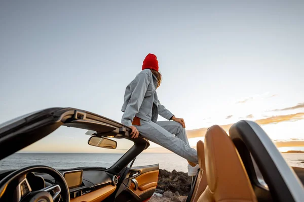 Mujer viajando en coche en la costa rocosa del océano — Foto de Stock