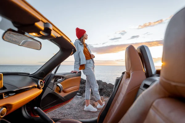 Woman traveling by car on the rocky ocean coast — Stock Photo, Image