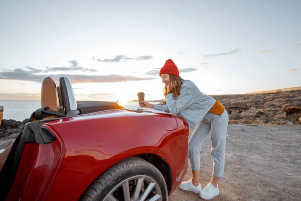 Woman traveling by car on the rocky ocean coast — Stock Photo, Image
