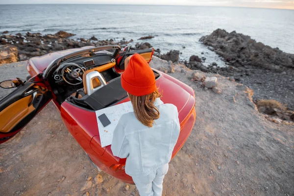 Mujer viajando en coche en la costa rocosa del océano — Foto de Stock