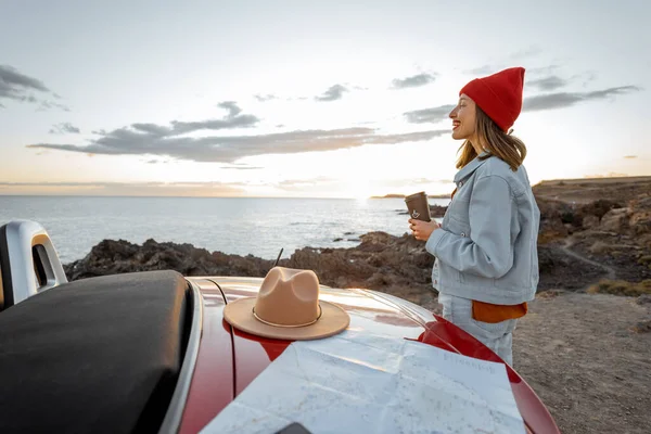 Woman traveling by car on the rocky ocean coast — Stockfoto