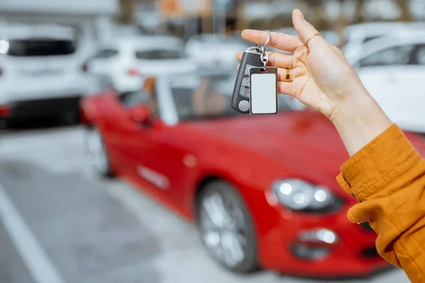 Woman holding keychain at the car parking — Stockfoto