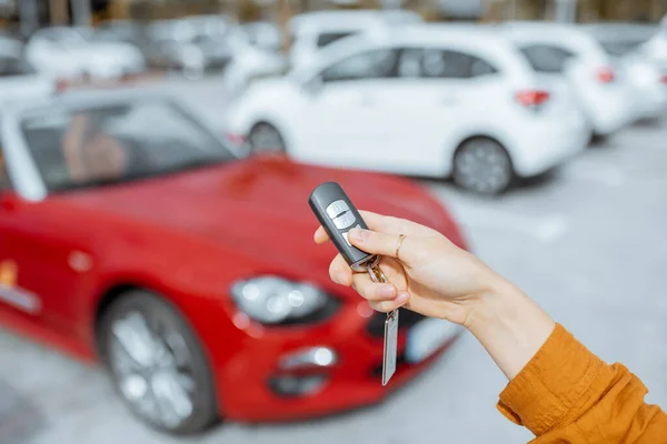 Woman holding keychain at the car parking — 图库照片