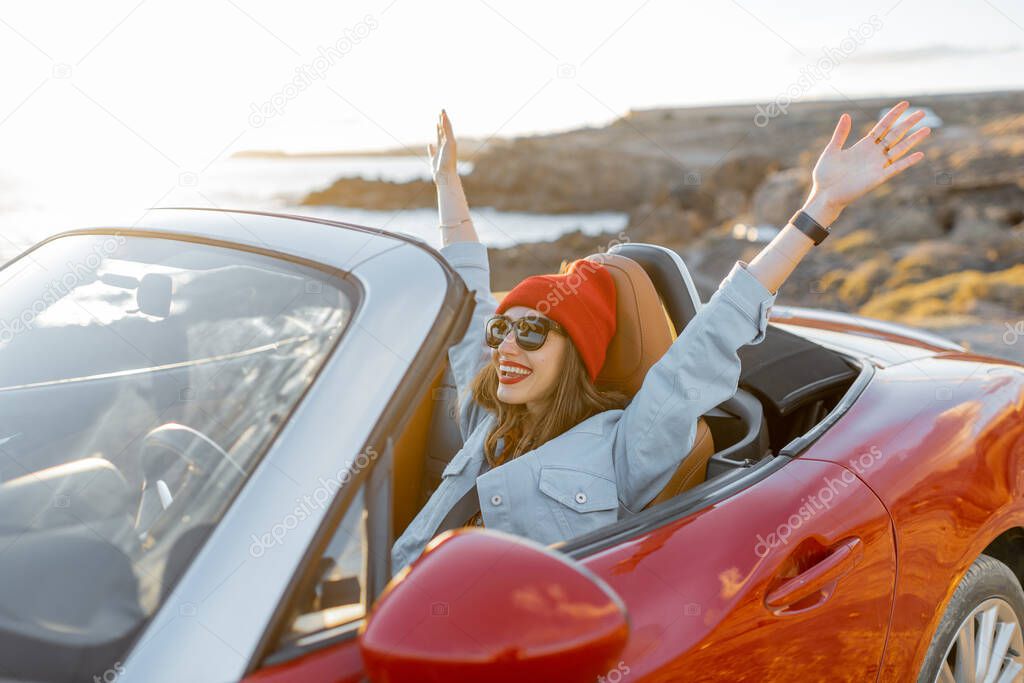 Woman traveling by car on the rocky coastline