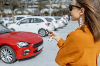 Woman with car keys at the parking