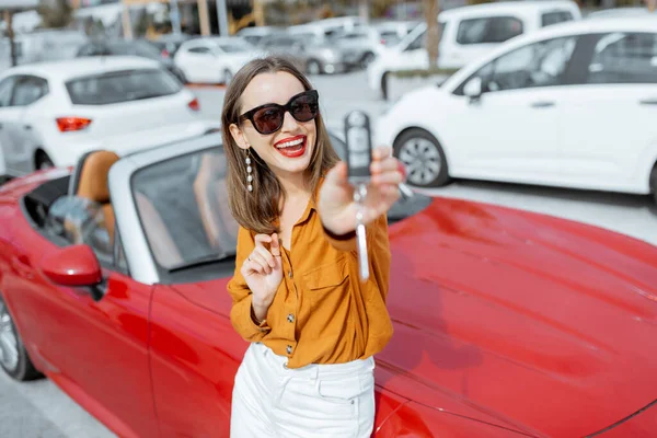 Mulher feliz com chaves perto do carro no estacionamento — Fotografia de Stock