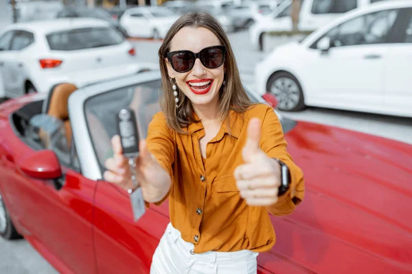 Mulher feliz com chaves perto do carro no estacionamento — Fotografia de Stock