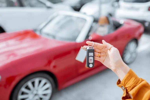 Mulher segurando chaveiro no estacionamento do carro — Fotografia de Stock