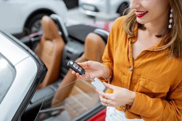 Woman holding keychain at the car parking — Stock fotografie