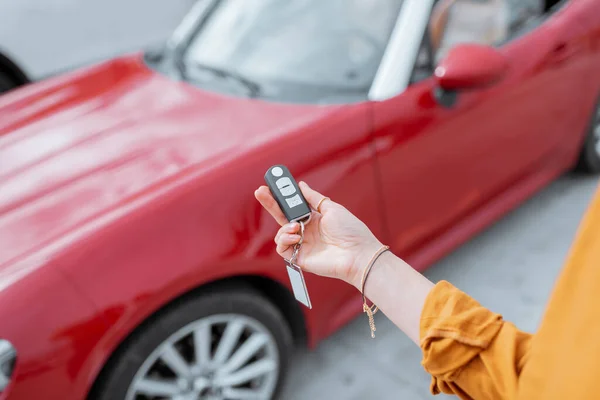 Mulher segurando chaveiro no estacionamento do carro — Fotografia de Stock