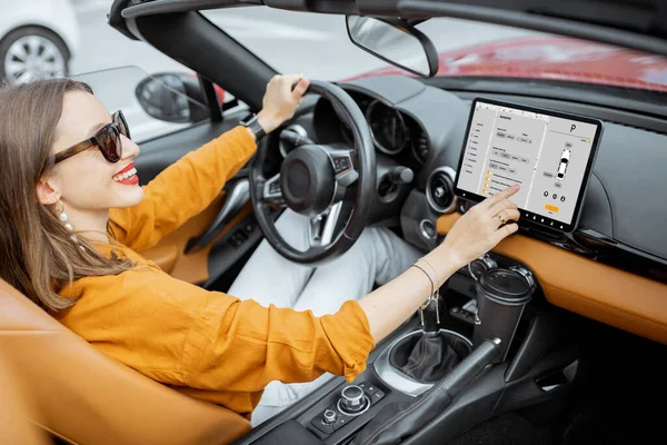 Mulher que controla o carro com um painel digital — Fotografia de Stock