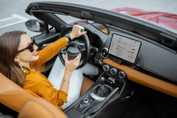 Женщина за рулем спортивного автомобиля с цифровым сенсорным экраном — стоковое фото