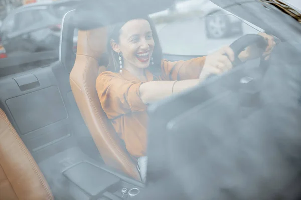 Счастливая женщина за рулем машины — стоковое фото