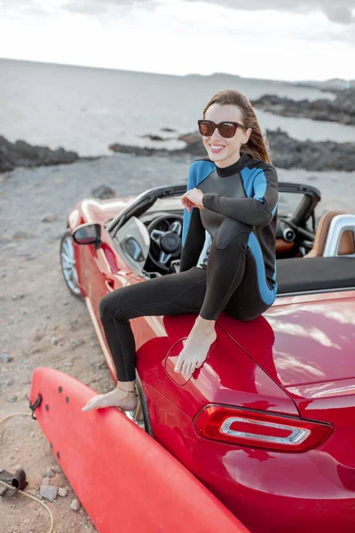 Young surfer with surfboard on the sports car on the beach — Stok fotoğraf