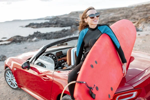 Young surfer with surfboard on the sports car on the beach — Stock Photo, Image