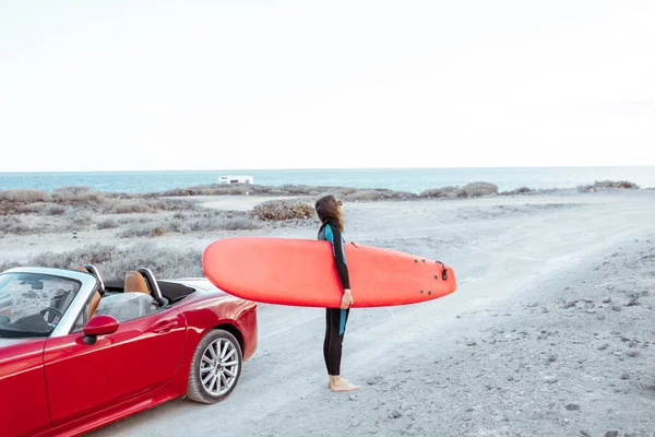 Sahilde sörf tahtası olan kadın. — Stok fotoğraf