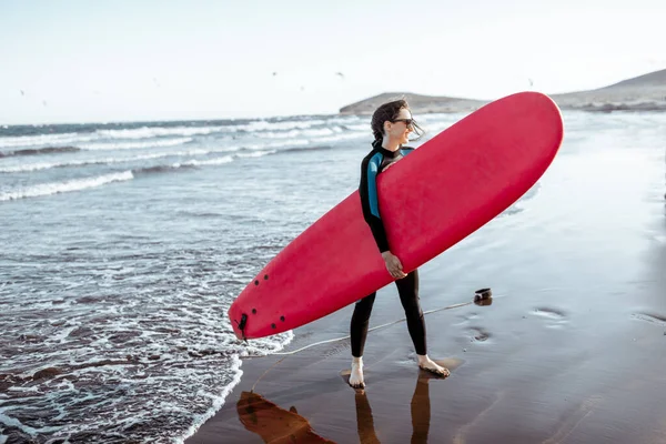 Frau mit Surfbrett am Strand — Stockfoto