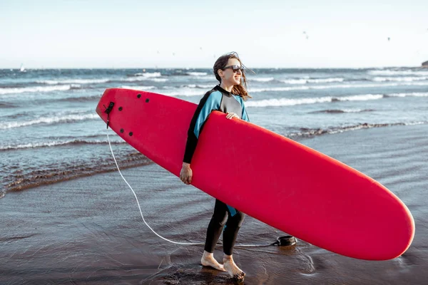 Plajda sörf tahtası olan kadın. — Stok fotoğraf