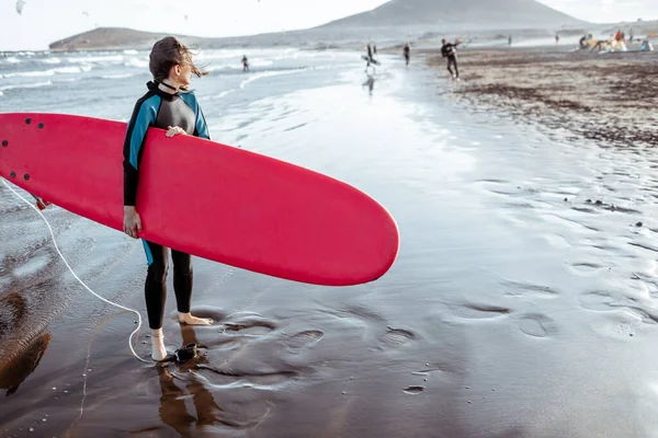 Frau mit Surfbrett am Strand — Stockfoto