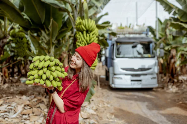 Woman with banana stem on the pantation — Zdjęcie stockowe