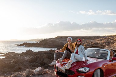 Okyanus kenarında arabayla seyahat eden sevimli bir çift.