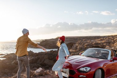 Okyanus kenarında arabayla seyahat eden sevimli bir çift.
