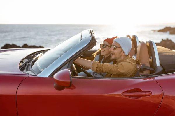 Casal encantador dirigindo um cabriolet perto do oceano — Fotografia de Stock