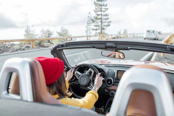 Mulher dirigindo um cabriolet na estrada da montanha — Fotografia de Stock