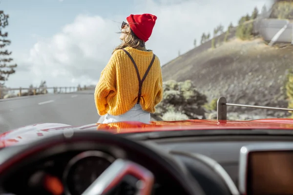 Kvinna tjärnar med bil på bergsvägen — Stockfoto
